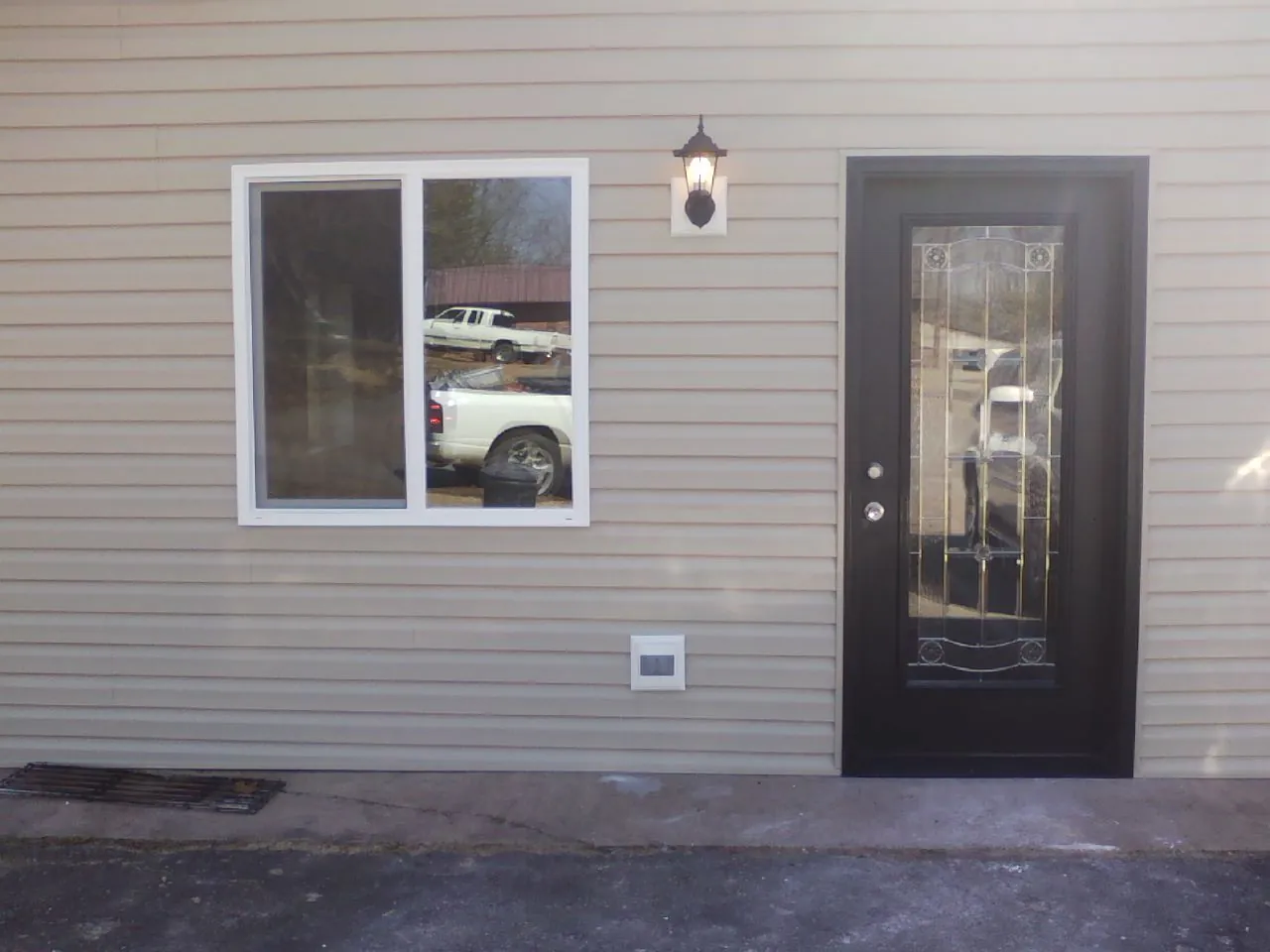 New siding, window and entry door on the side of an addition in Clayton